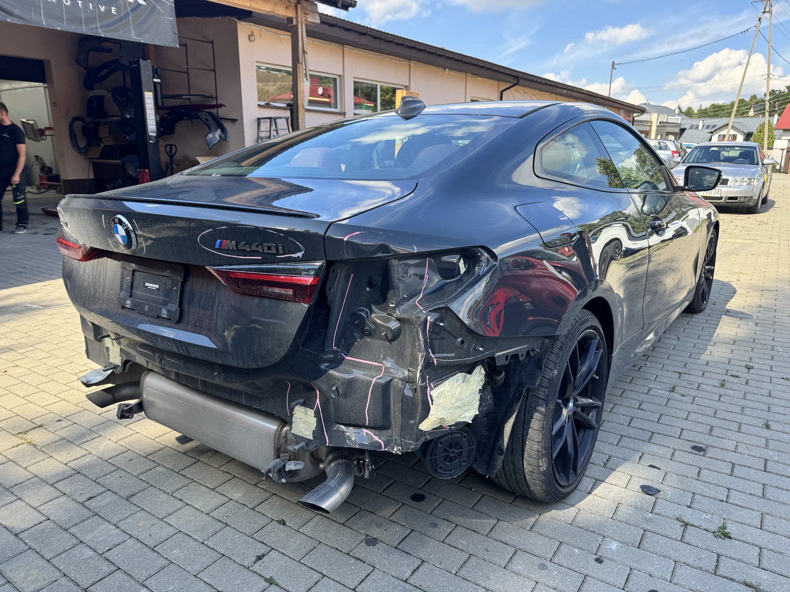 BMW z odsłoniętym uszkodzonym tyłem podczas weryfikacji zakresu naprawy